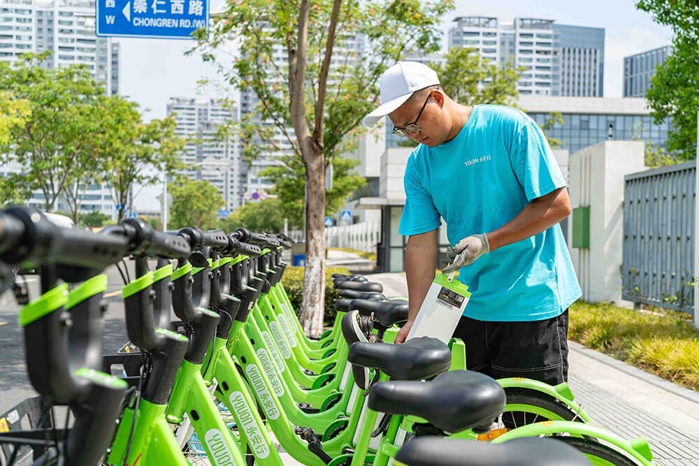 安行換電員劉揚正在給助力自行車(chē)換電